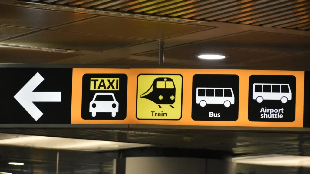 Signs for taxi, train, bus and airport shuttle transport.