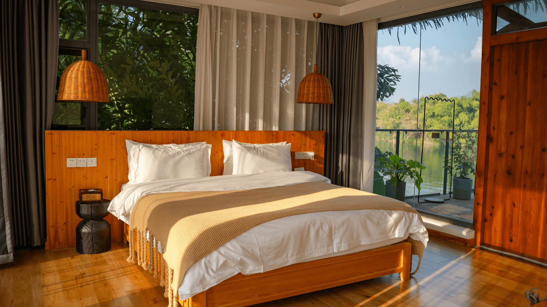 Travel accommodation with a double bed and balcony overlooking the water.