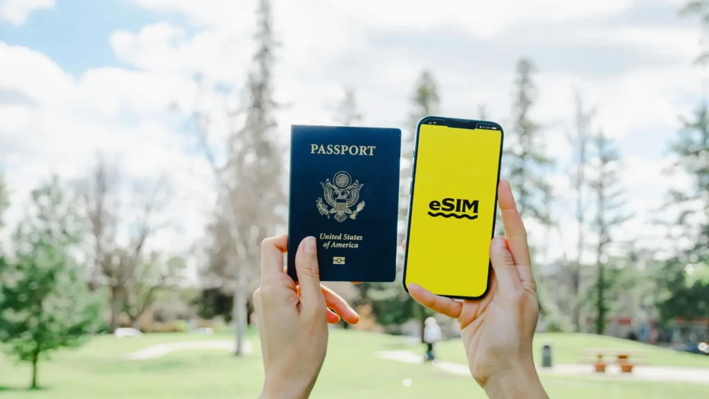 Traveller holding a passport and smartphone displaying an eSIM screen.