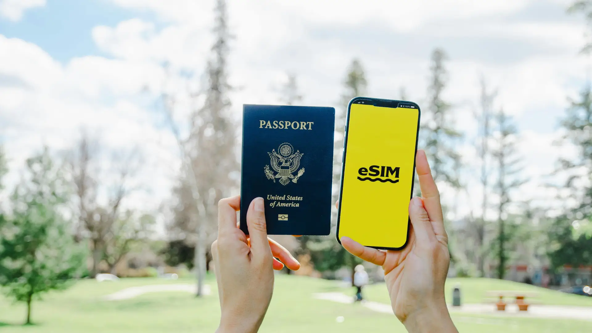 Traveller holding a passport and smartphone displaying an eSIM screen.