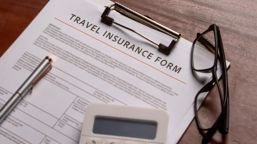 Travel insurance form with glasses and calculator.